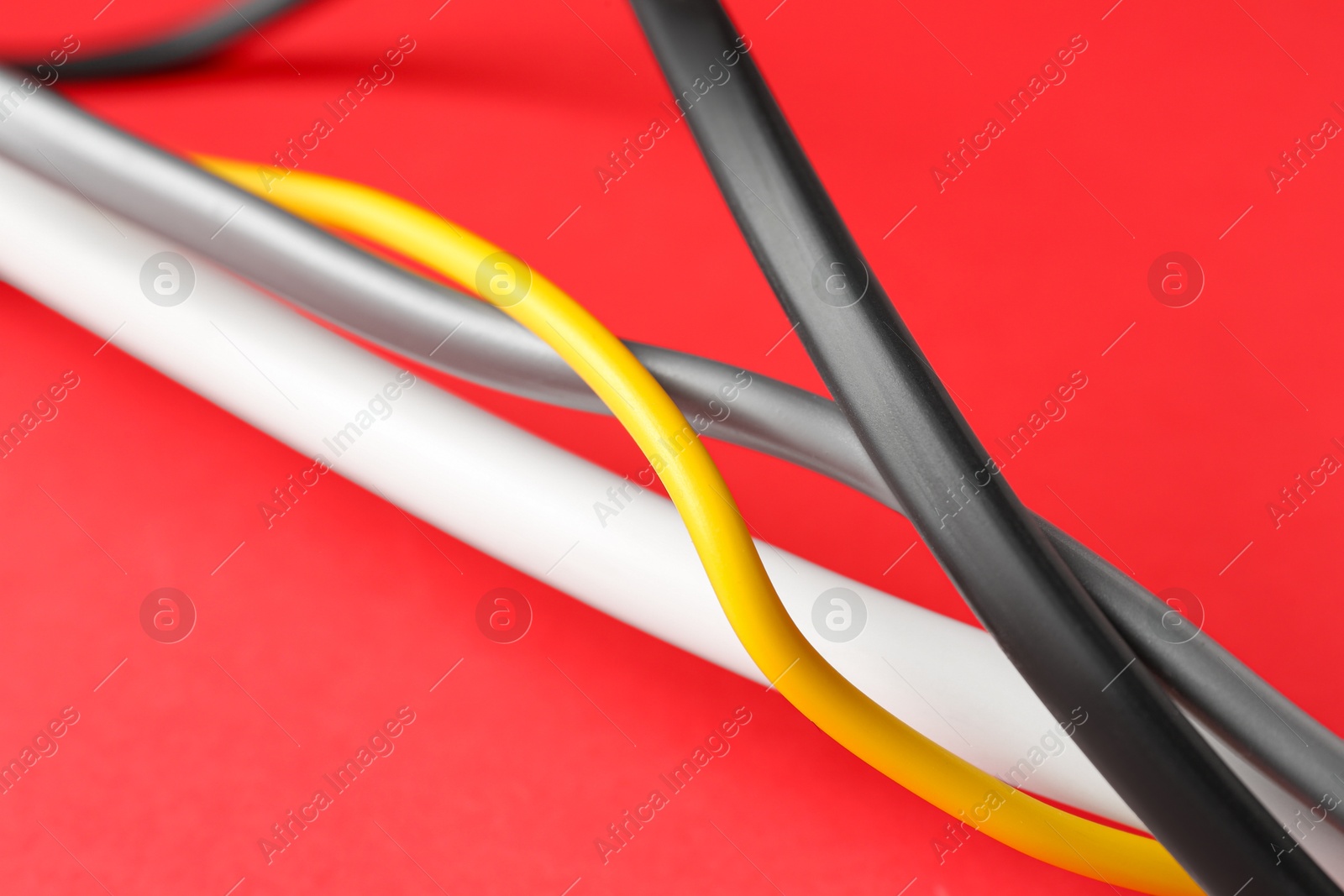 Photo of Color electrical wires on red background, closeup