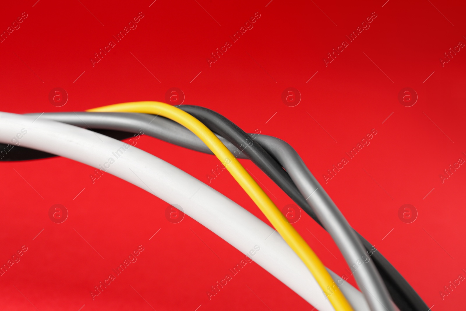 Photo of Color electrical wires on red background, closeup