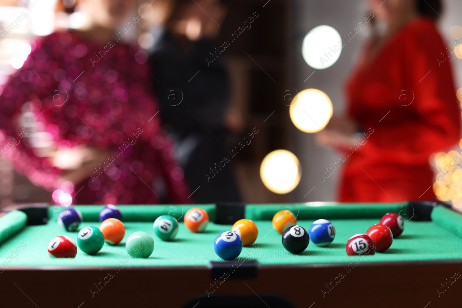 Photo of People near green billiard table with many colorful balls indoors, selective focus