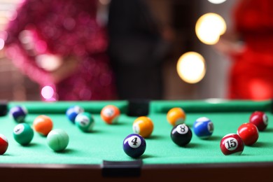 Photo of Many colorful billiard balls on green table indoors, closeup. Space for text