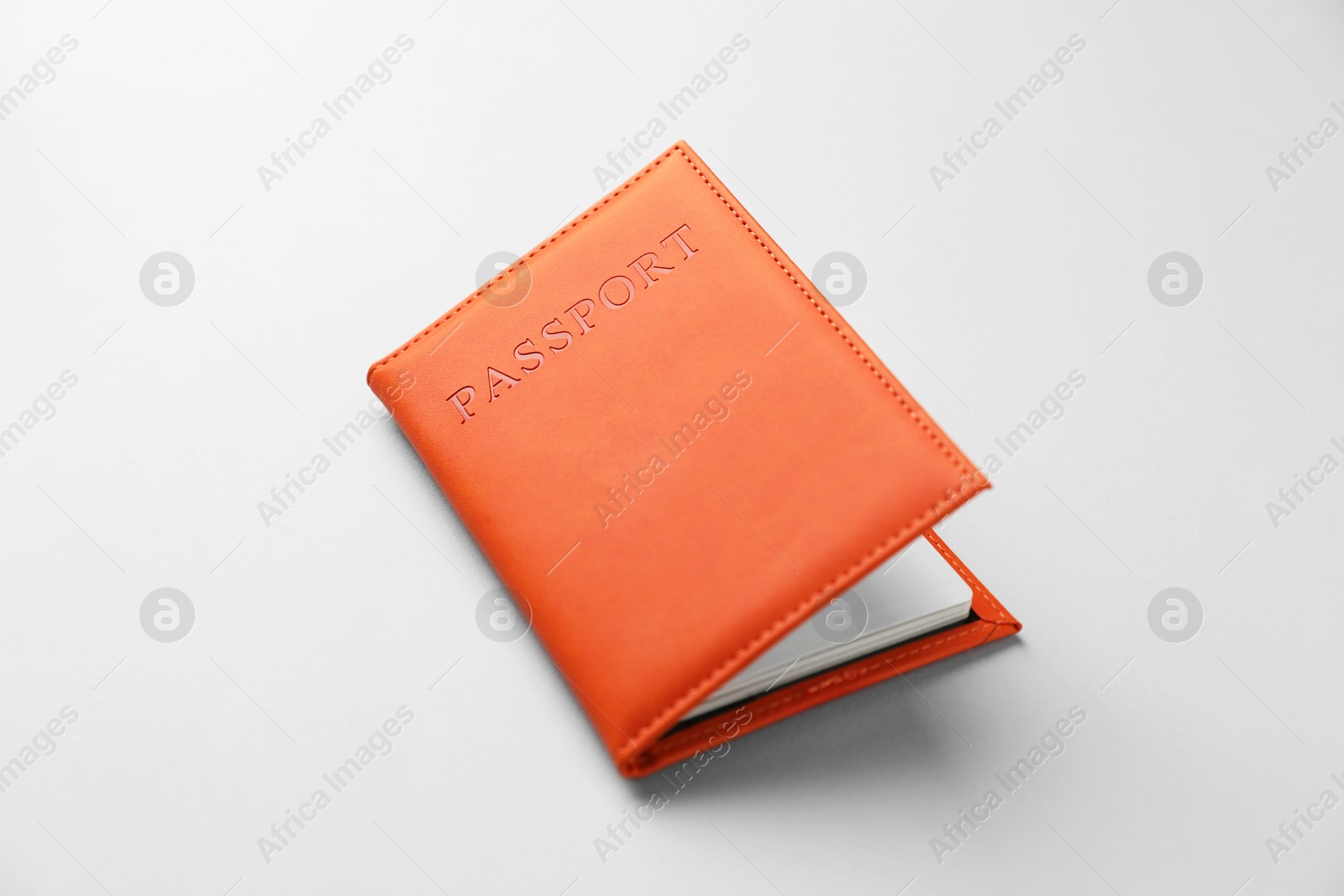 Photo of Passport in bright cover on grey background, closeup