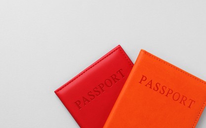 Photo of Passports in bright covers on grey background, top view. Space for text