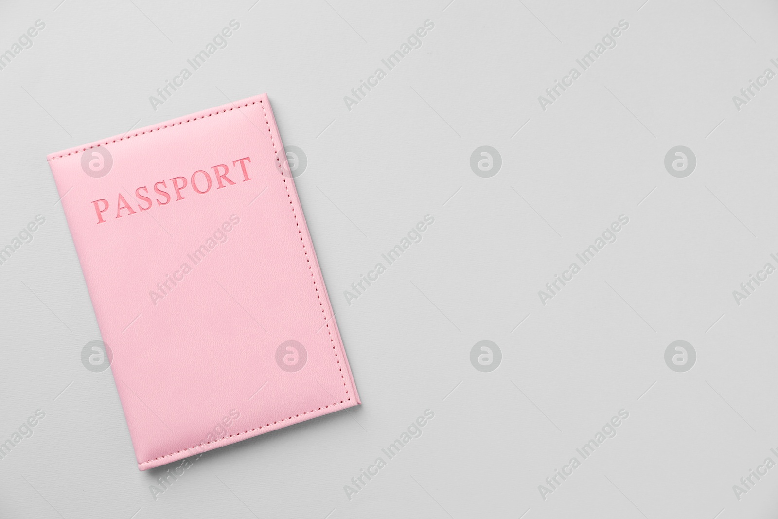 Photo of Passport in bright cover on grey background, top view. Space for text