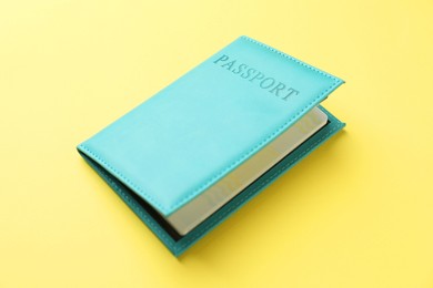 Photo of Passport in bright cover on yellow background, closeup