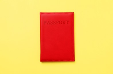 Photo of Passport in bright cover on yellow background, top view