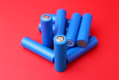 Photo of Many AA cell batteries on red background, closeup