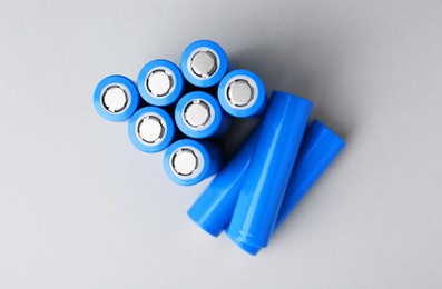 Photo of Many AA cell batteries on light grey background, top view