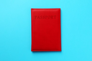 Photo of Passport in red cover on light blue background, top view