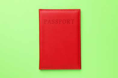 Photo of Passport in red cover on green background, top view