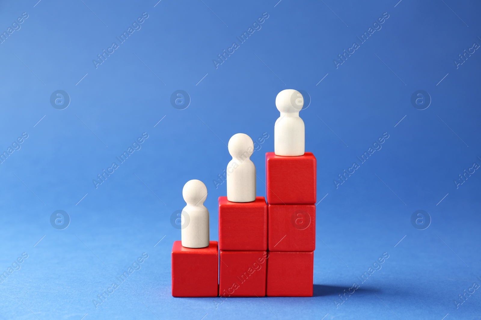 Photo of Competition concept. Human figures on ladder against blue background