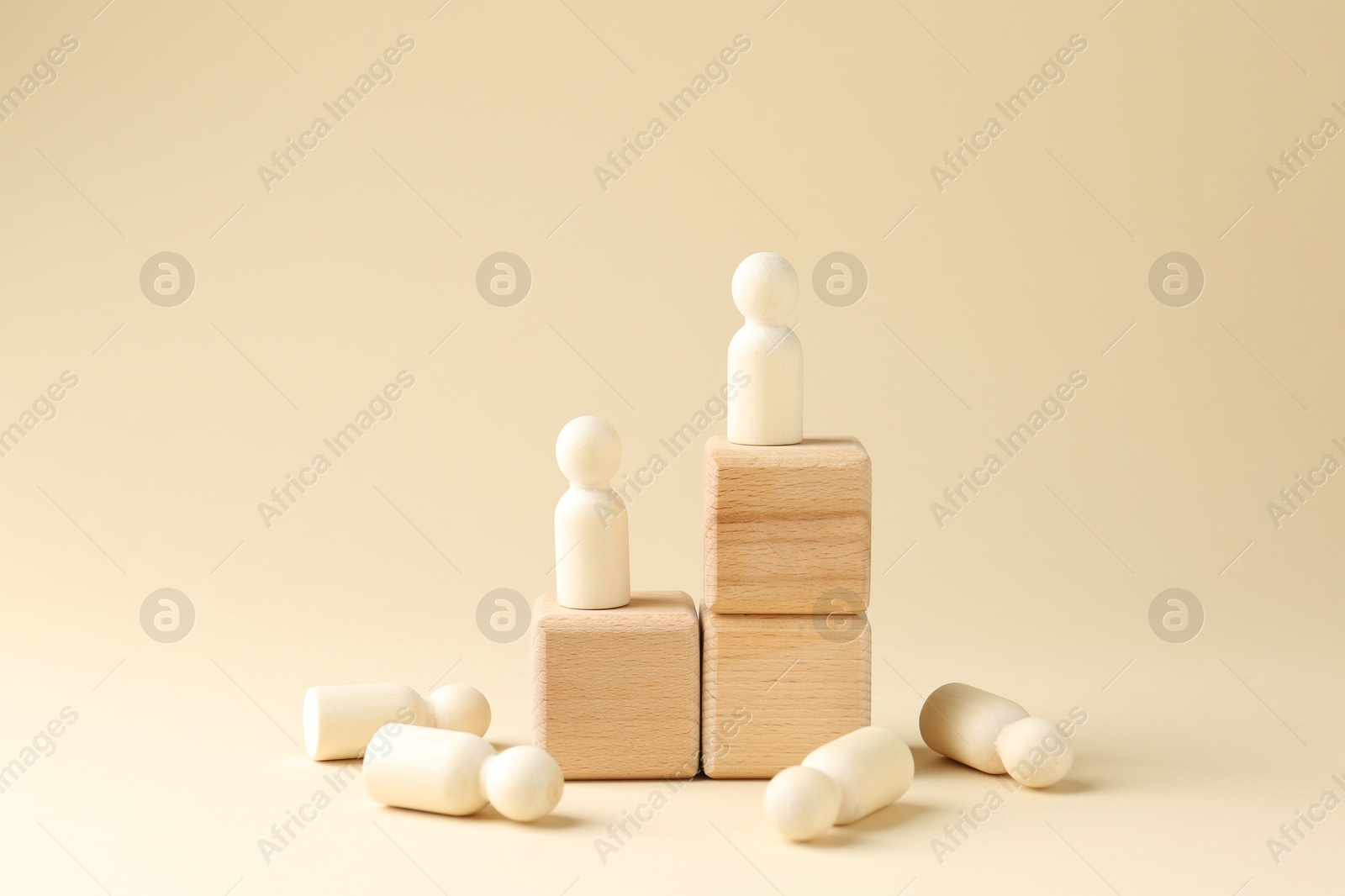 Photo of Competition concept. Human figures on wooden cubes and other ones behind against beige background, space for text