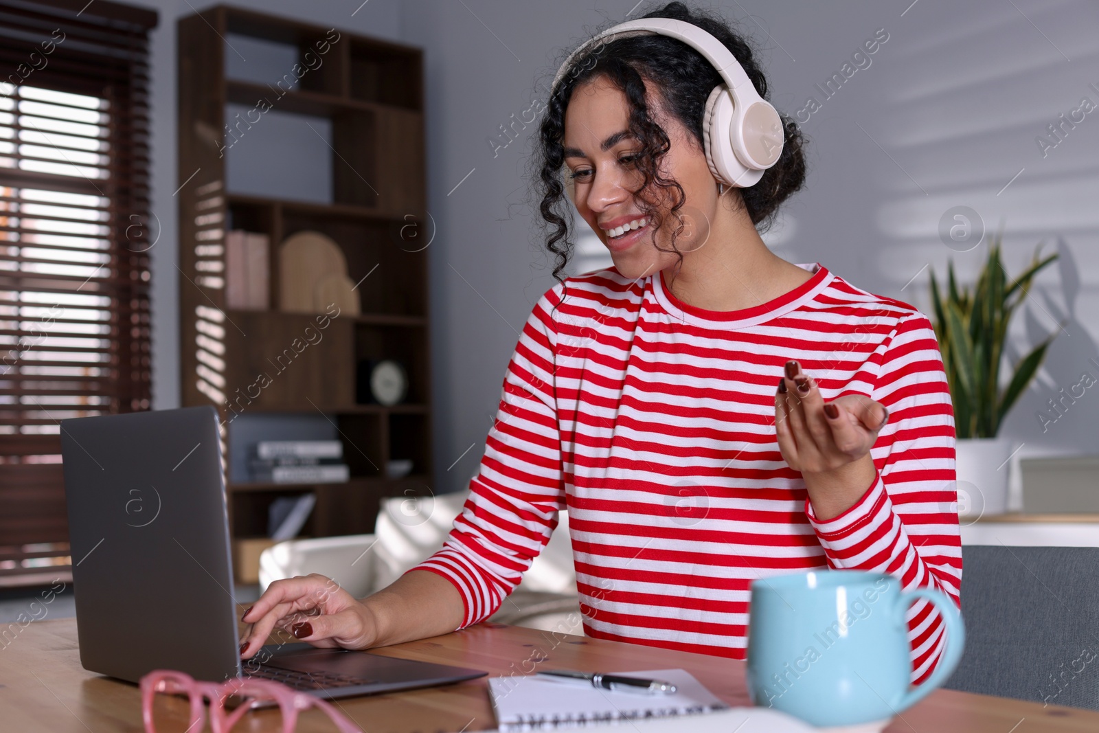 Photo of Beautiful woman working on laptop at desk in home office