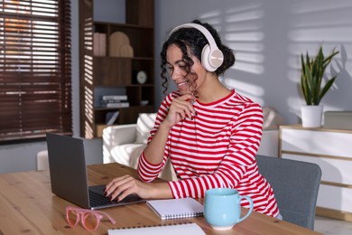 Photo of Beautiful woman working on laptop at desk in home office