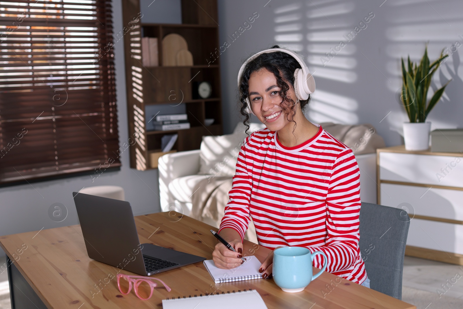 Photo of Beautiful woman working on laptop at desk in home office