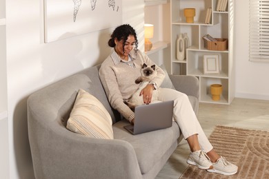 Photo of Beautiful woman with her cute cat working on laptop at home