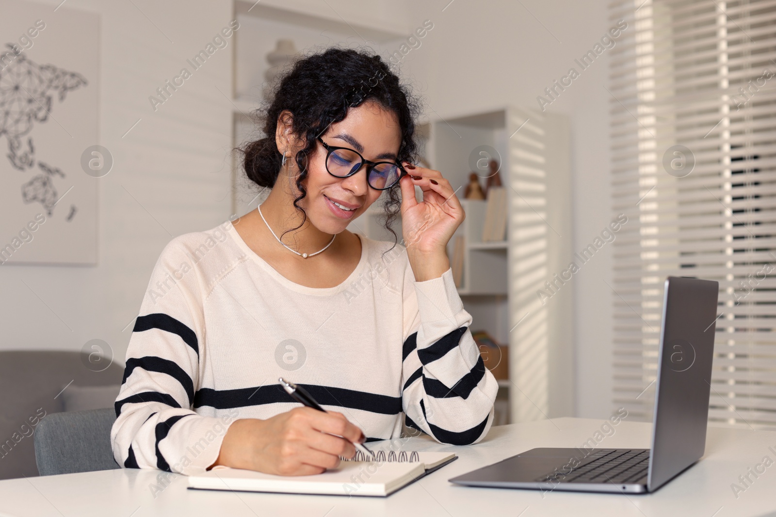 Photo of Beautiful woman working on laptop at desk in home office