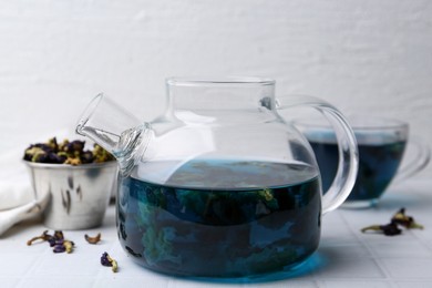 Delicious butterfly pea flower tea on white tiled table