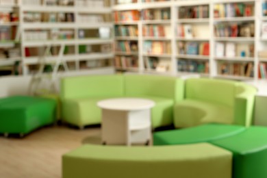 Photo of Stylish furniture in public library, blurred view