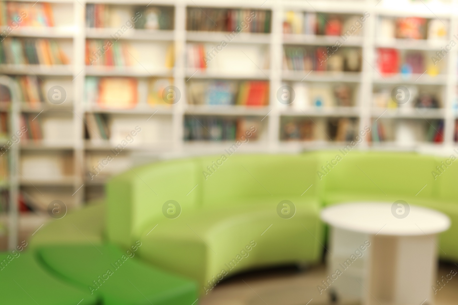 Photo of Stylish furniture in public library, blurred view