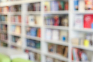 Photo of Bookcase with books in public library, blurred view