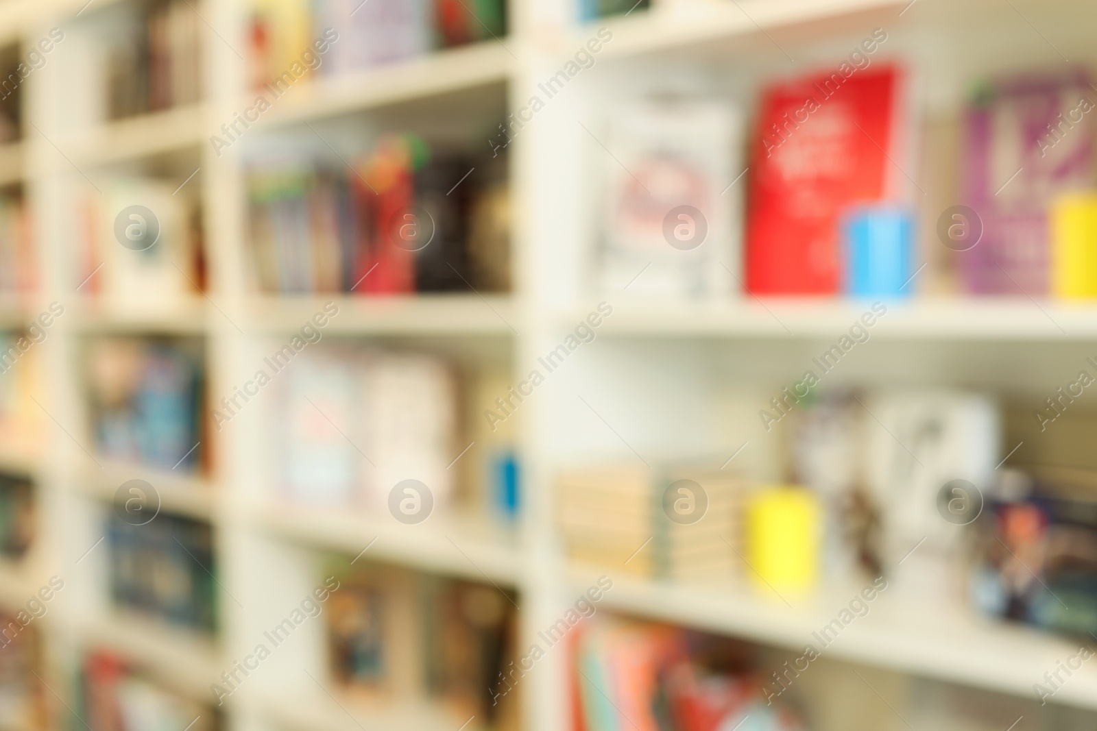 Photo of Bookcase with books in public library, blurred view