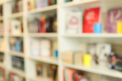 Photo of Bookcase with books in public library, blurred view