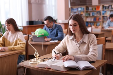 Photo of Group of people working at desks in public library