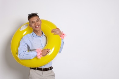 Photo of Businessman with inflatable ring and wreaths of flowers on white background, space for text