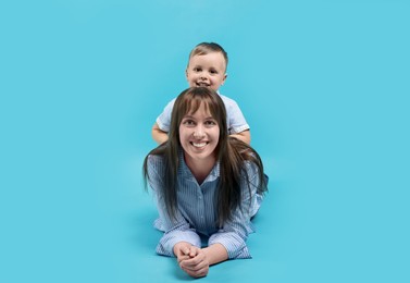 Photo of Mother and her cute son on light blue background