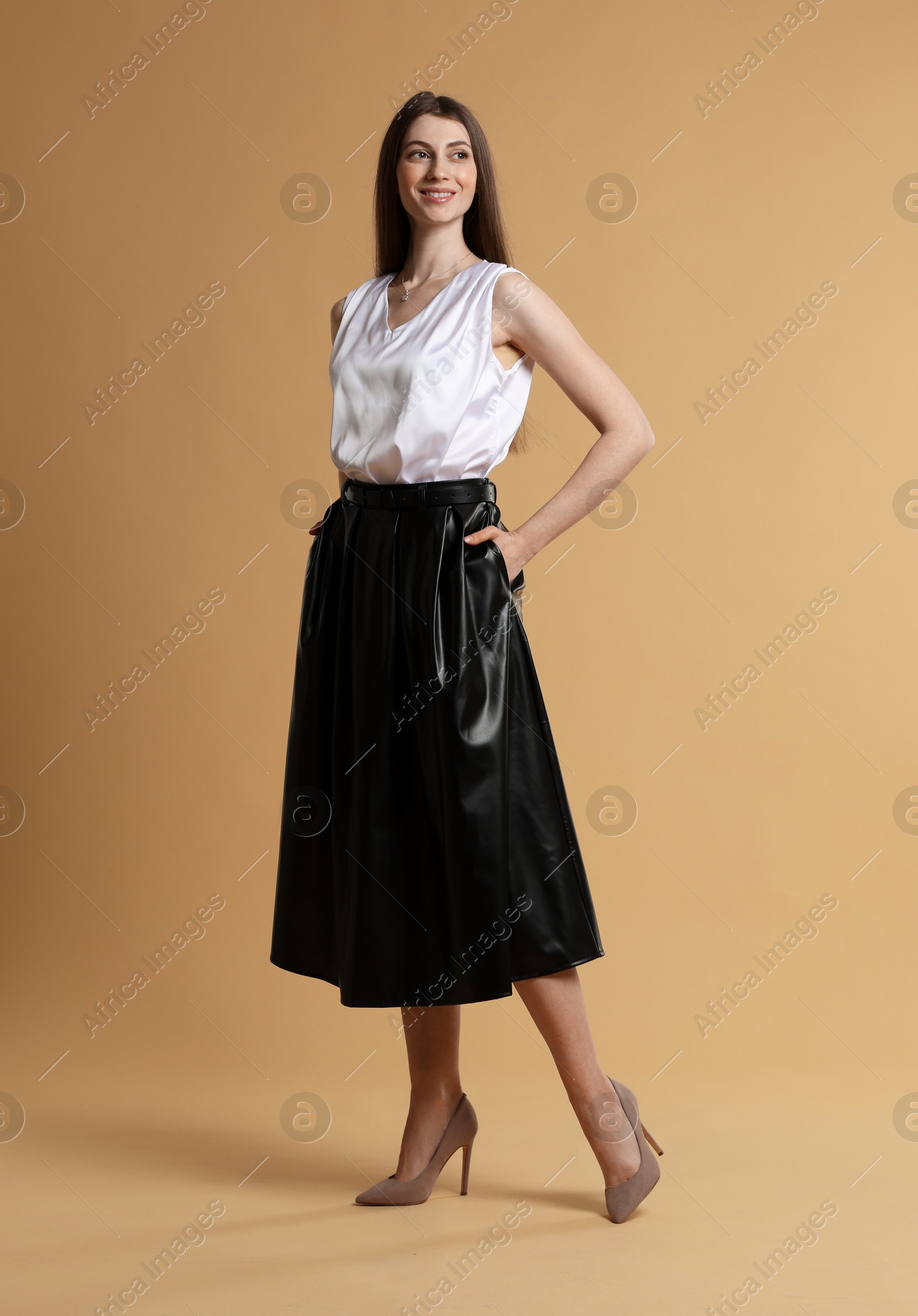 Photo of Beautiful woman in stylish outfit on beige background