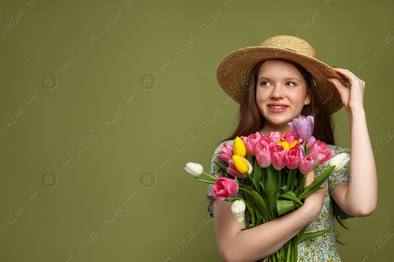 Photo of Beautiful teenage girl with bouquet of tulips on olive background, space for text