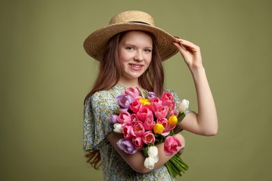 Photo of Beautiful teenage girl with bouquet of tulips on olive background