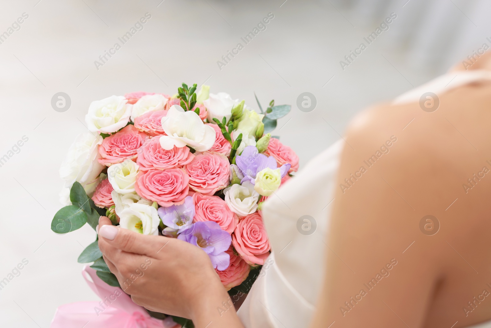 Photo of Bride with beautiful wedding bouquet on light background, closeup