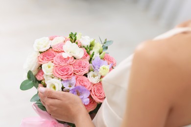 Photo of Bride with beautiful wedding bouquet on light background, closeup