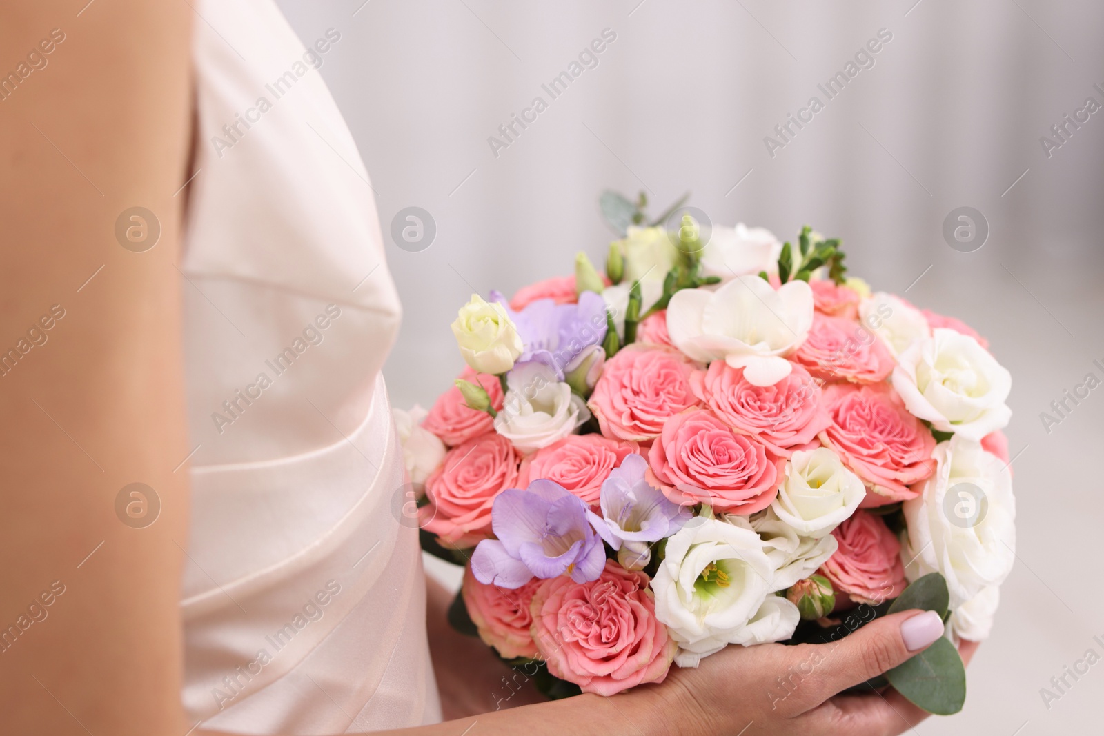 Photo of Bride with beautiful wedding bouquet on light background, closeup