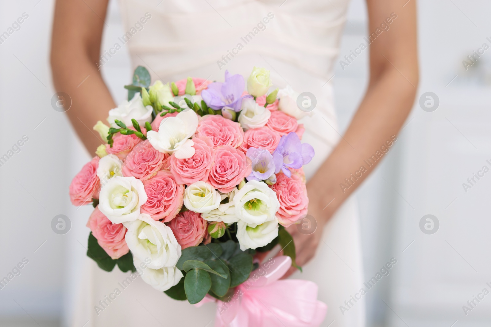 Photo of Bride with beautiful wedding bouquet on light background, closeup