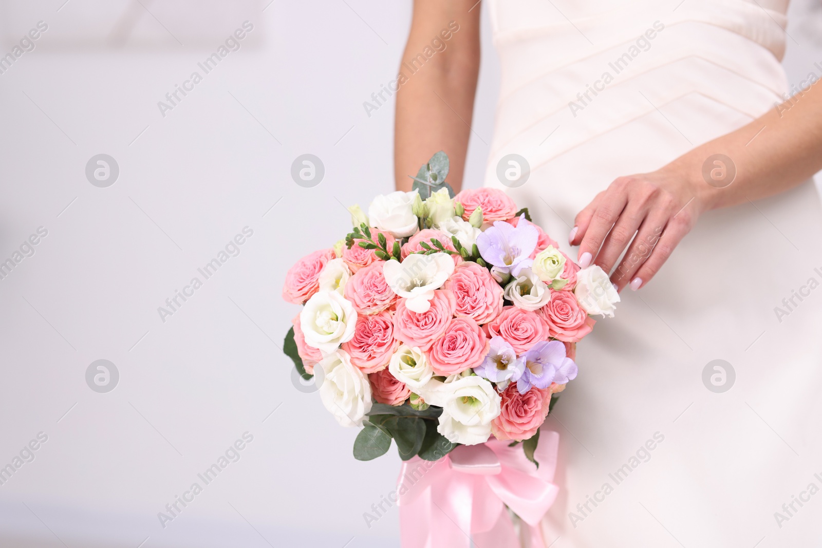 Photo of Bride with beautiful wedding bouquet on light background, closeup. Space for text