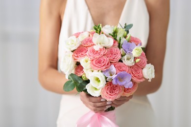 Photo of Bride with beautiful wedding bouquet on light background, closeup