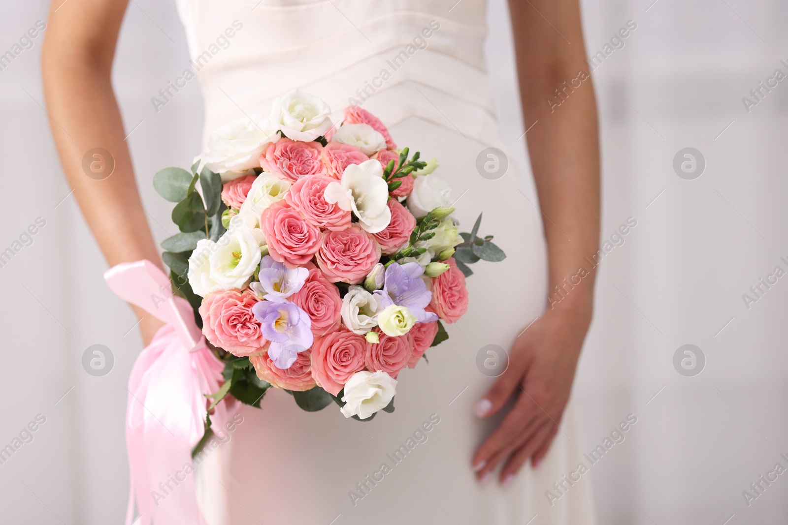 Photo of Bride with beautiful wedding bouquet on light background, closeup