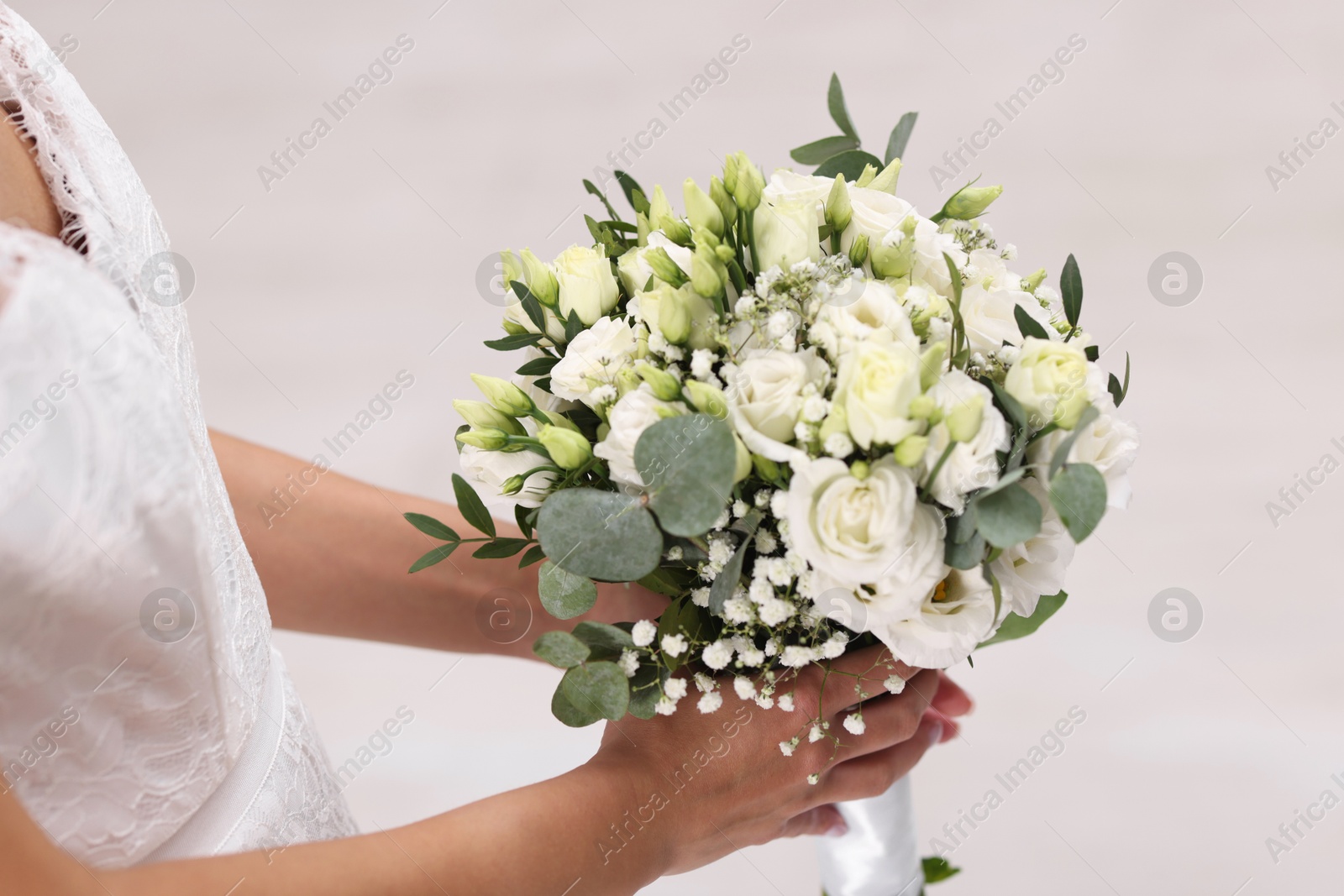 Photo of Bride with beautiful wedding bouquet on light background, closeup