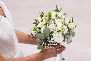 Photo of Bride with beautiful wedding bouquet on light background, closeup