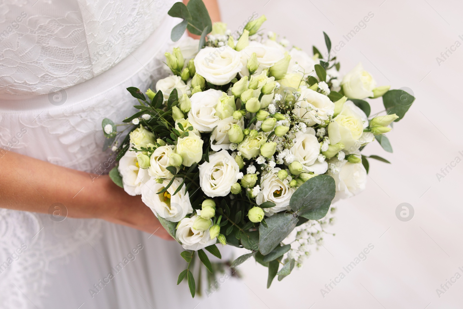 Photo of Bride with beautiful wedding bouquet on light background, closeup