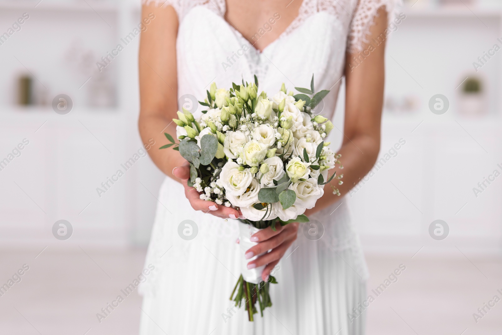 Photo of Bride with beautiful wedding bouquet on light background, closeup