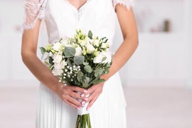 Photo of Bride with beautiful wedding bouquet on light background, closeup