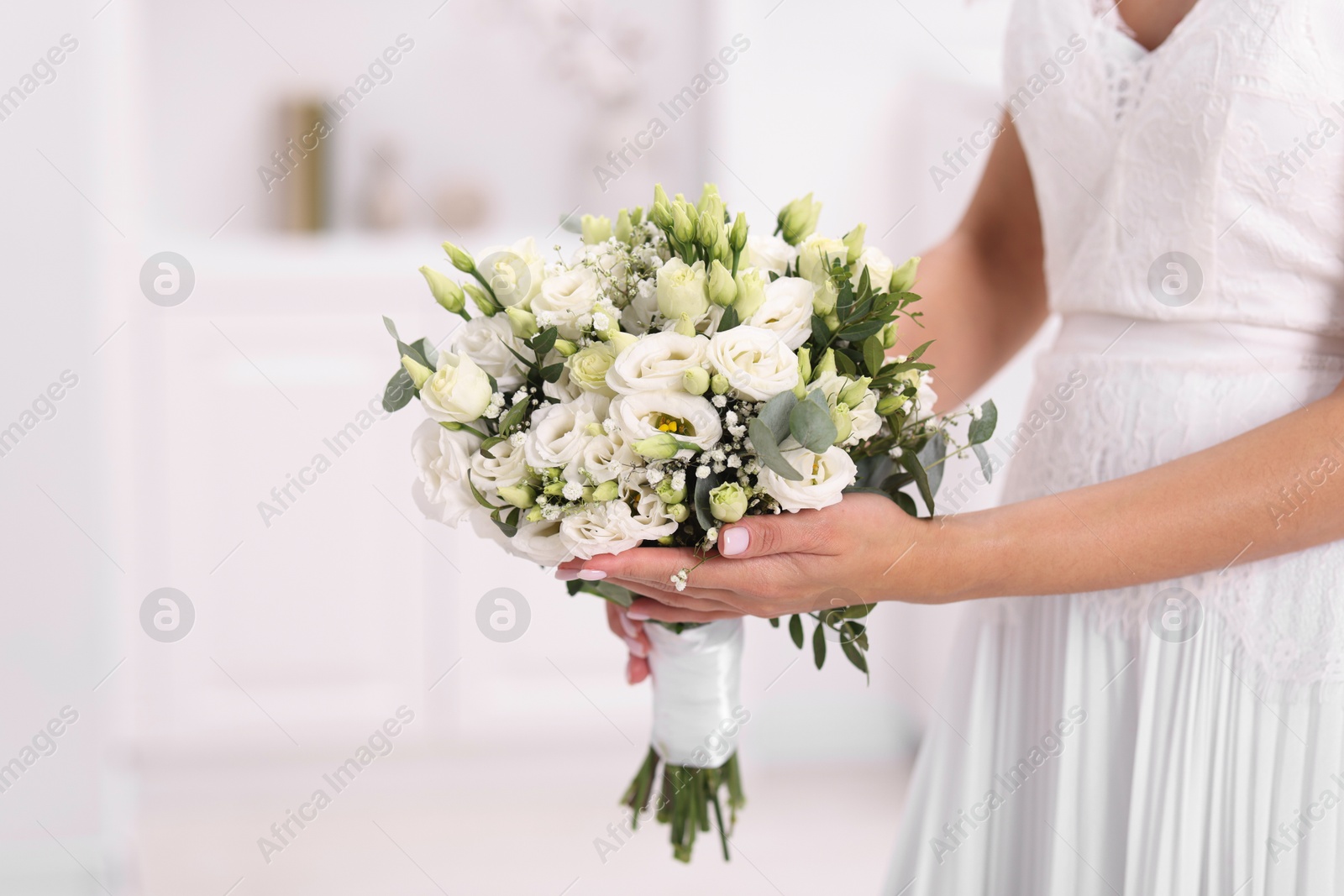 Photo of Bride with beautiful wedding bouquet on light background, closeup. Space for text