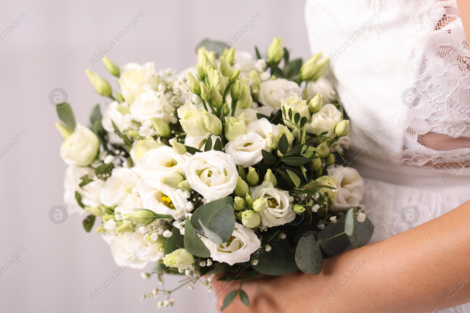 Photo of Bride with beautiful wedding bouquet on light background, closeup