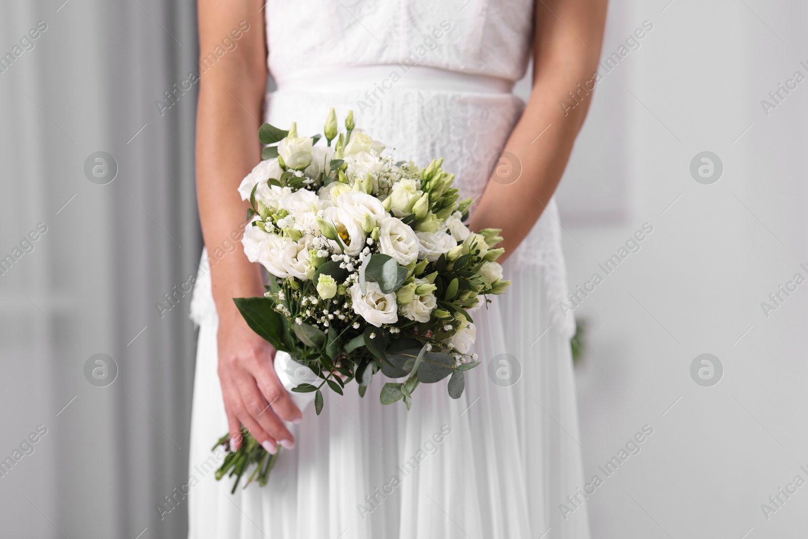 Photo of Bride with beautiful wedding bouquet on light background, closeup