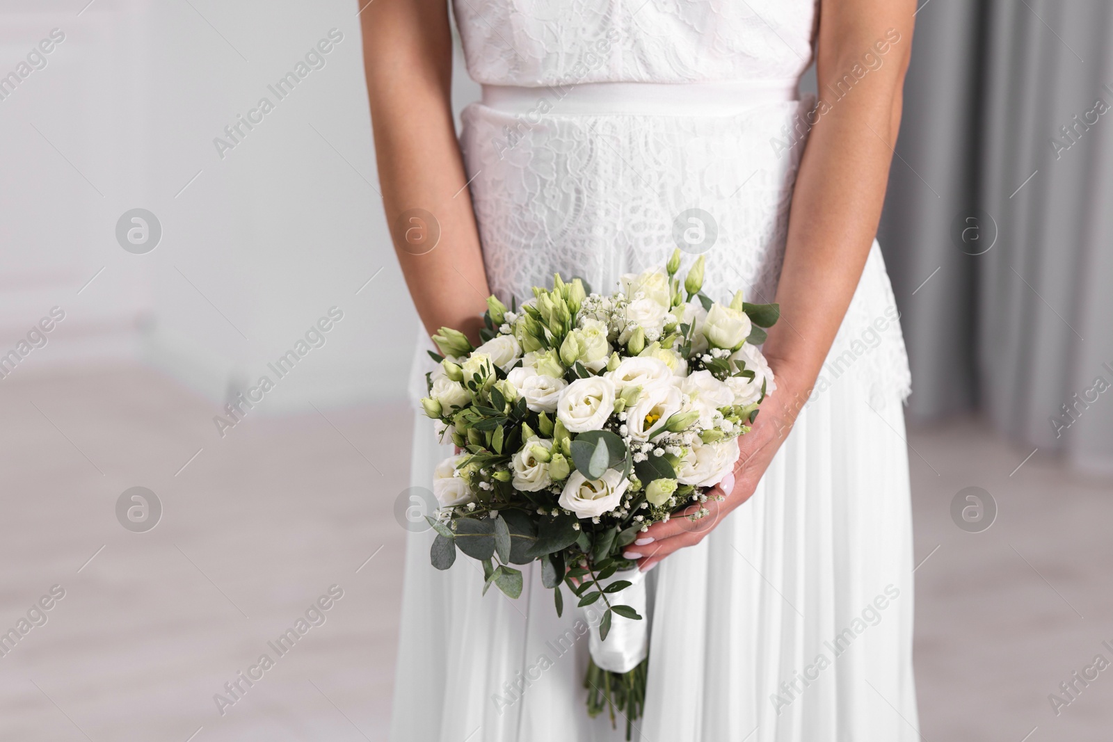 Photo of Bride with beautiful wedding bouquet on light background, closeup