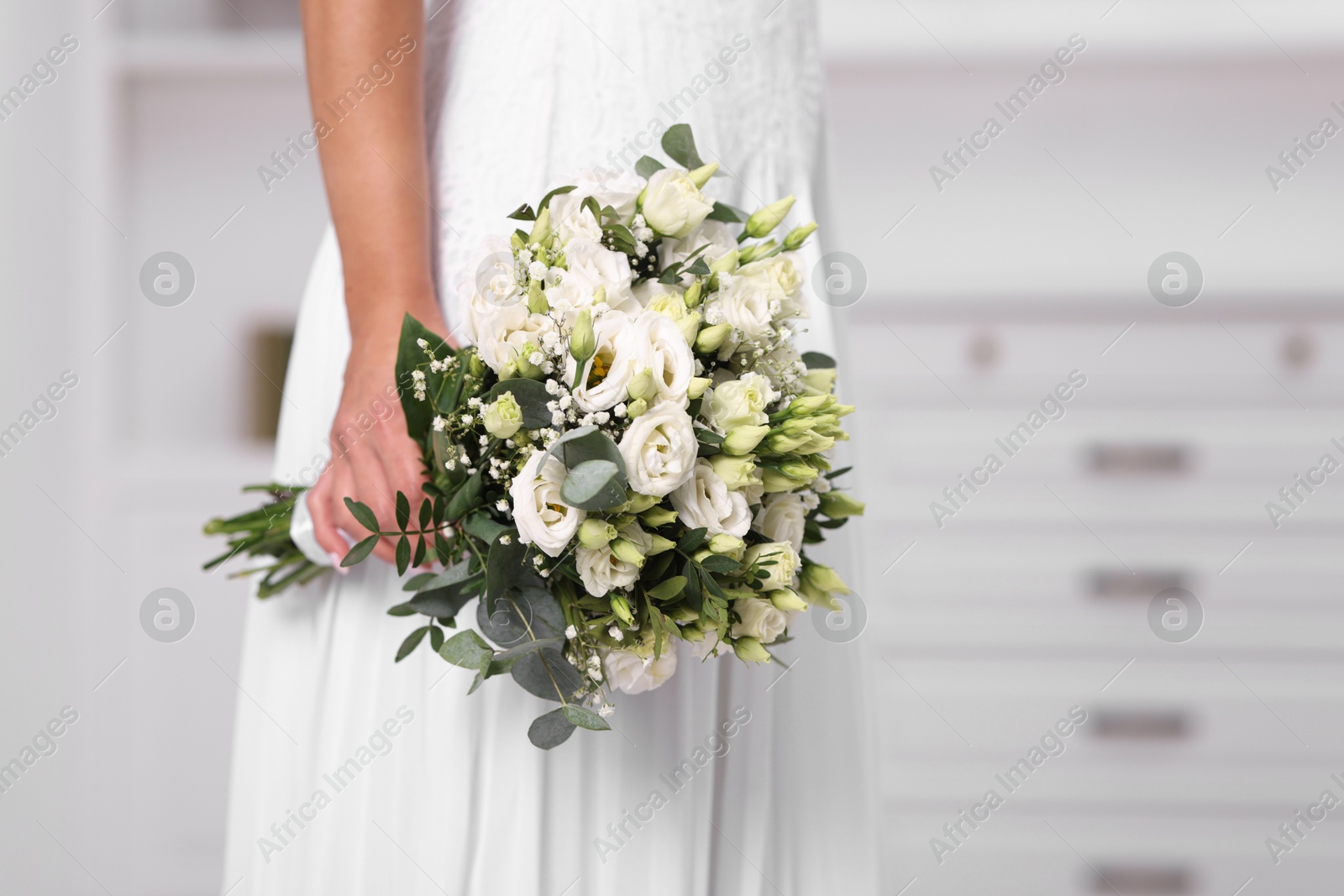 Photo of Bride with beautiful wedding bouquet on light background, closeup. Space for text