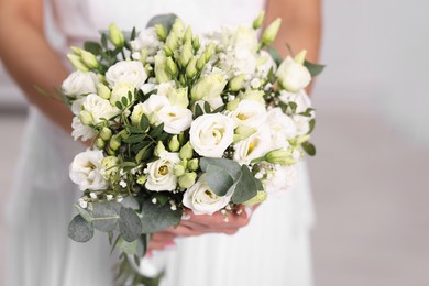 Photo of Bride with beautiful wedding bouquet on light background, closeup